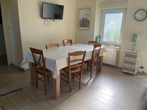 Salle à manger Table en bois avec chaises dans une salle à manger lumineuse, télévision murale.